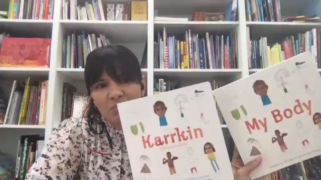 Woman holding two picture storybooks, one titled Karrkin and the other My Body