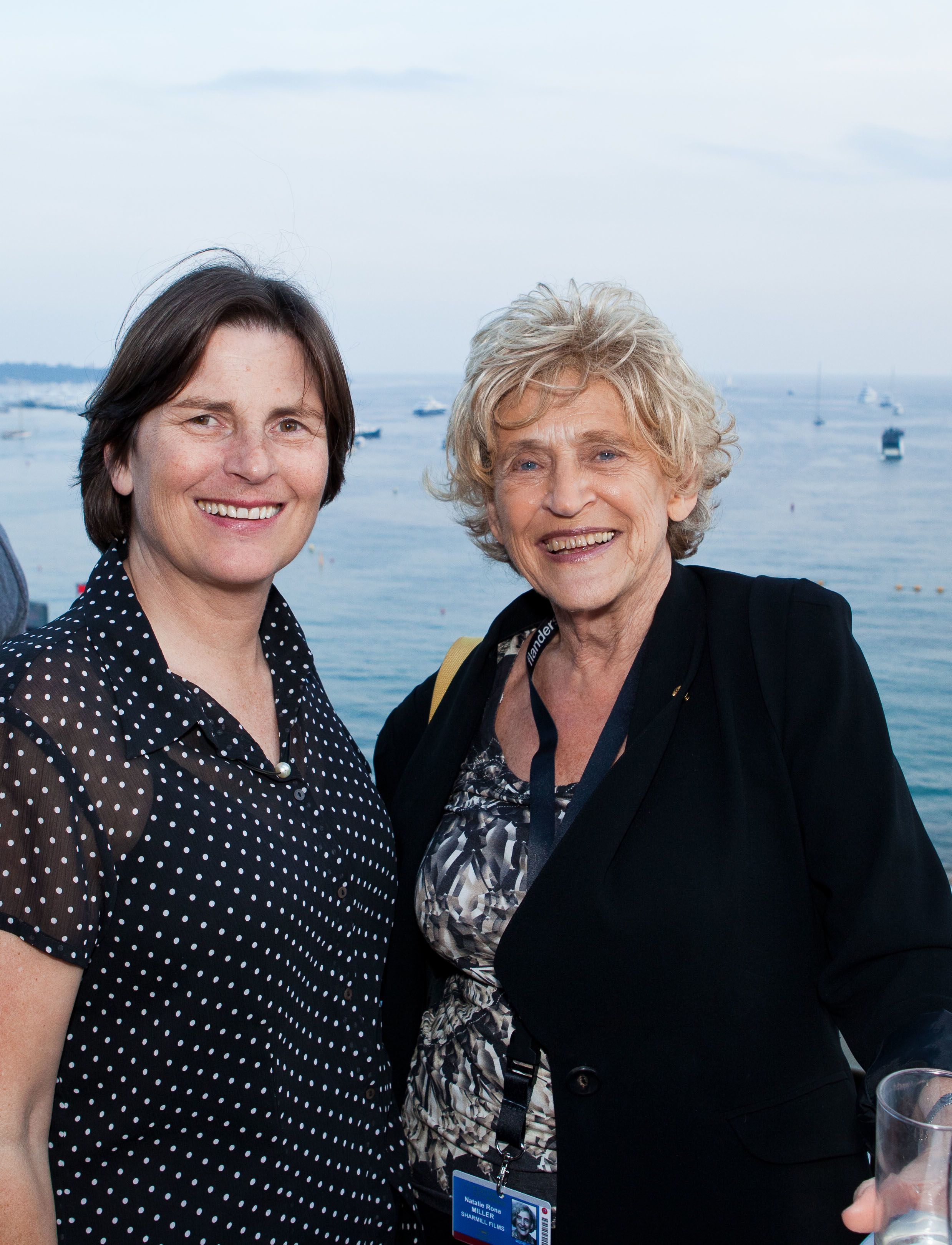 Sue (left) with Natalie Miller (right) standing in front of the ocean.