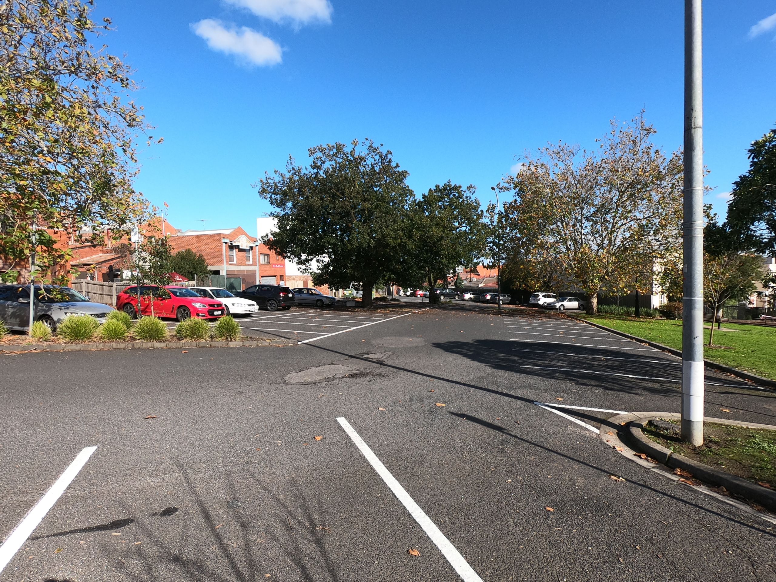 A carpark in Ivanhoe with only a few cars. It is mostly empty.