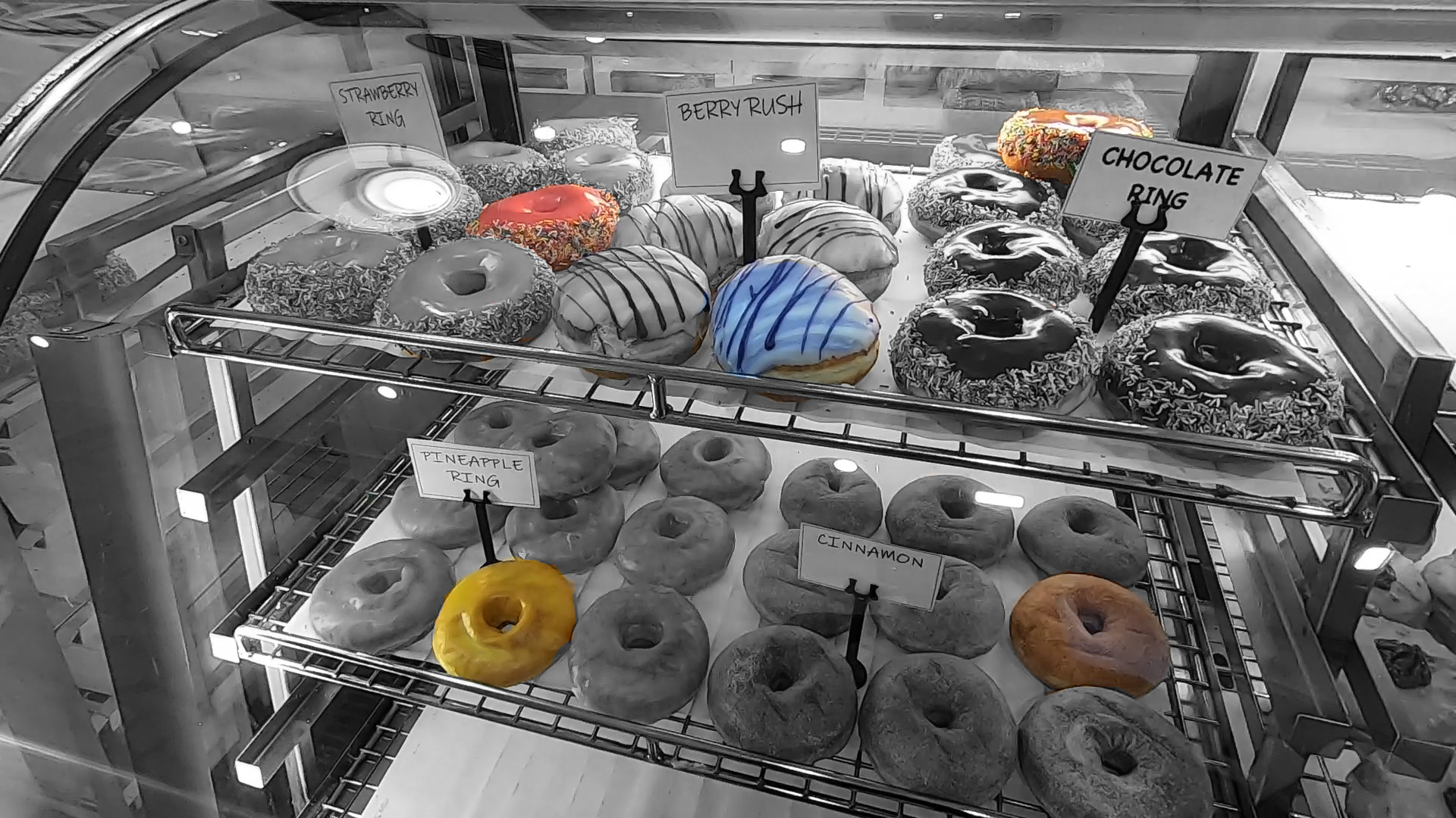 One doughnut of each flavour in the cabinet is now in full colour. The rest of the image is black and white.